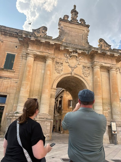 A historic building with ornate architecture, including a large archway and statues. 3