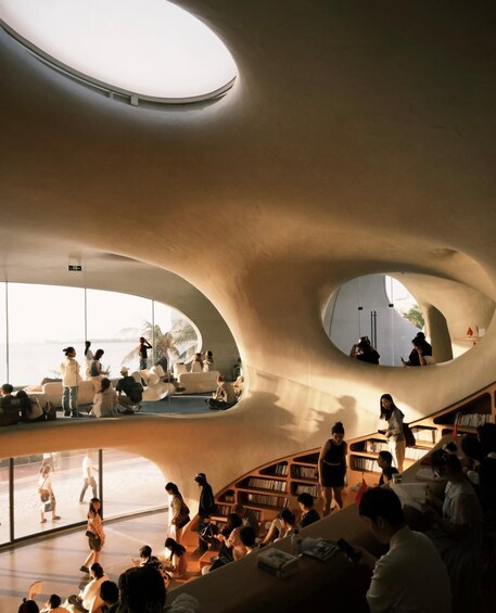 A modern library with unique architecture, featuring large circular windows and a central open space. 3