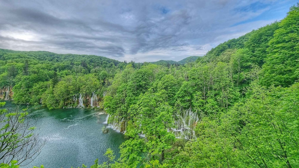 A lush green valley with a river and waterfalls. 3