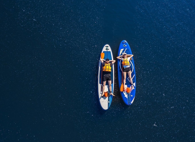 Two paddleboards on a dark blue water surface. 1
