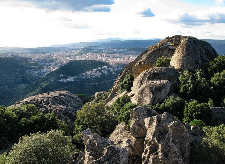 A mountainous landscape with rocky outcrops and a distant city view. 3