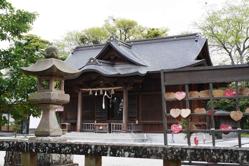 A traditional Japanese building with a tiled roof, surrounded by a stone lantern and a water feature. 3