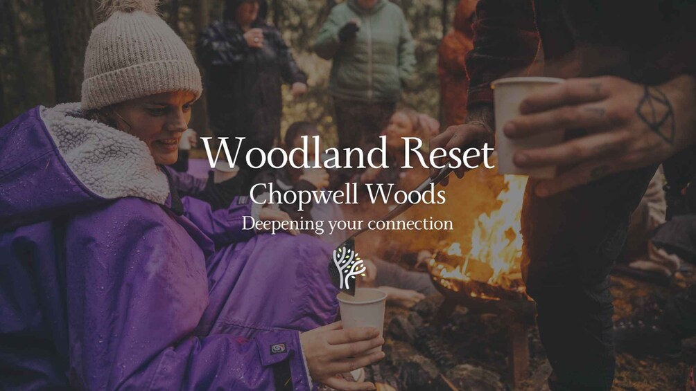 A group of people gathered around a campfire in a wooded area, wearing winter clothing. 1
