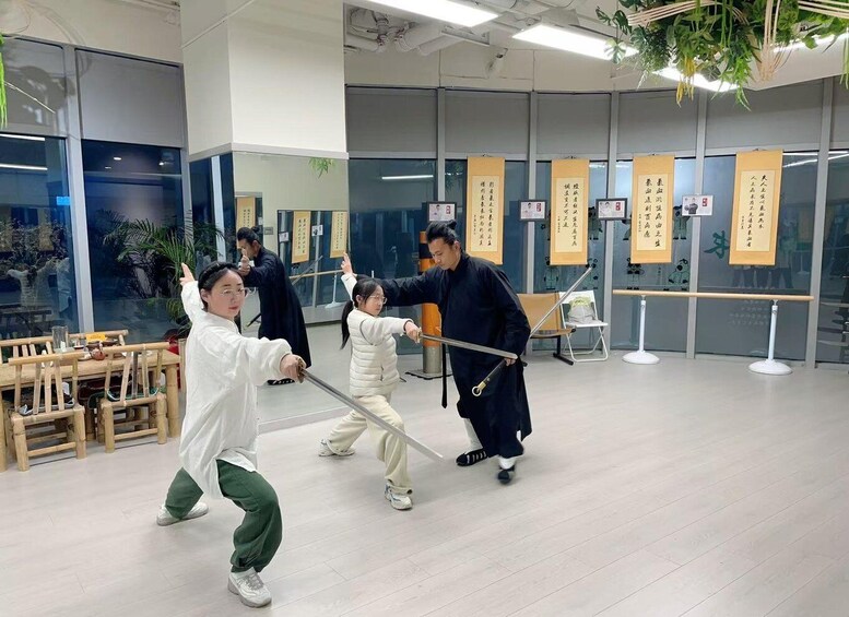 A martial arts training session with participants practicing with swords in a modern indoor facility. 5