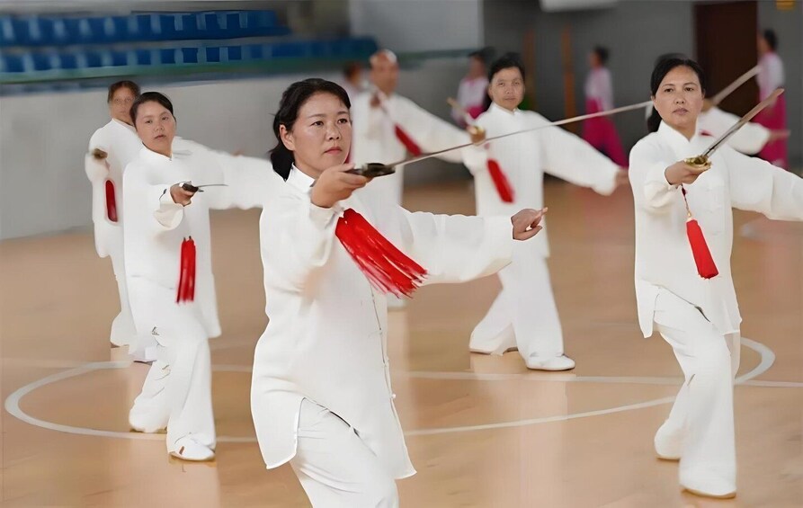 A group of people practicing martial arts in a gymnasium. 4
