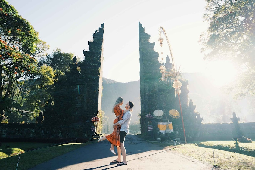 A couple embracing in front of ancient stone structures with a clear sky. 5