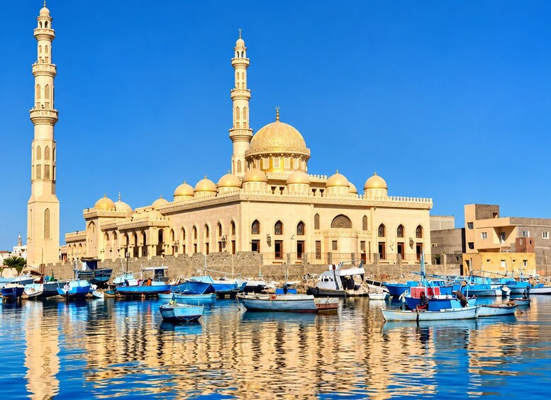 En moské med to minareter og en stor kuppel, omgivet af både på stille vand. 4