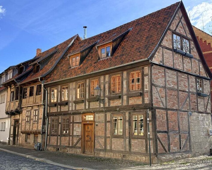 A traditional half-timbered building with a steeply pitched roof and a wooden door. 2