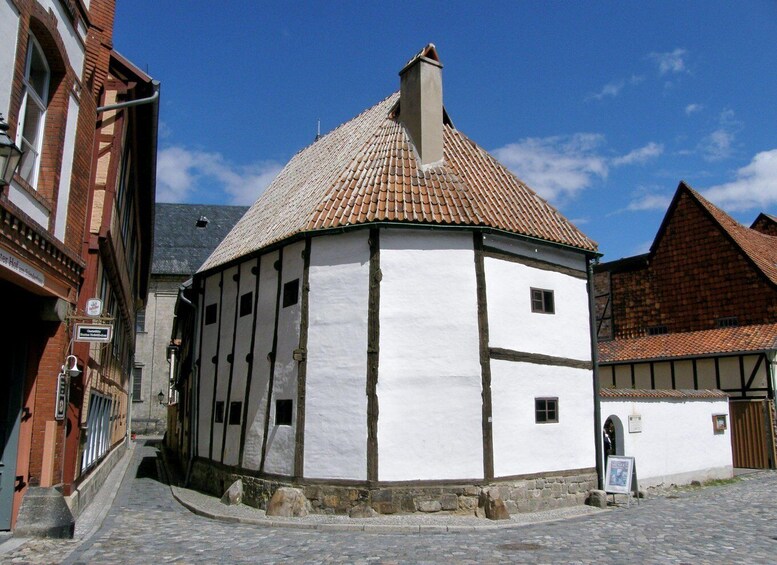 A traditional half-timbered house with a tiled roof and a cobblestone street. 5