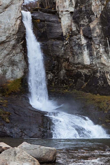 A waterfall cascading down a rocky cliff into a pool. 2