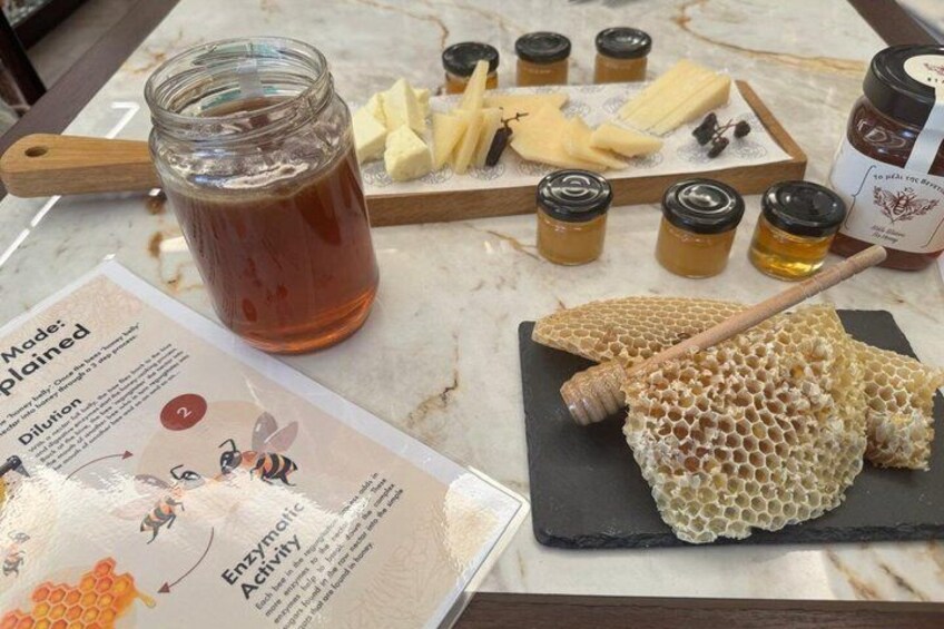 A jar of honey, honeycomb, and jars of honey on a marble table. 5