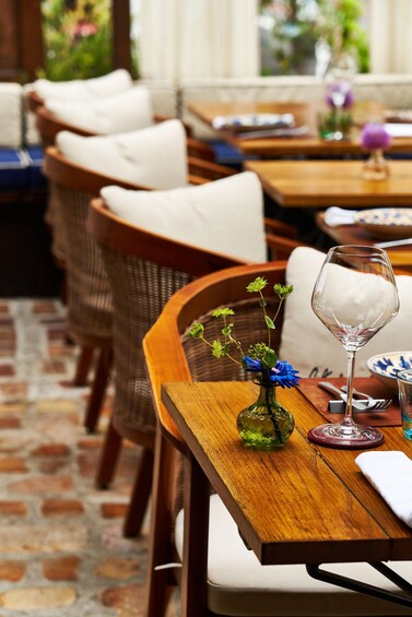 A wooden table with a glass vase and a wine glass. 3