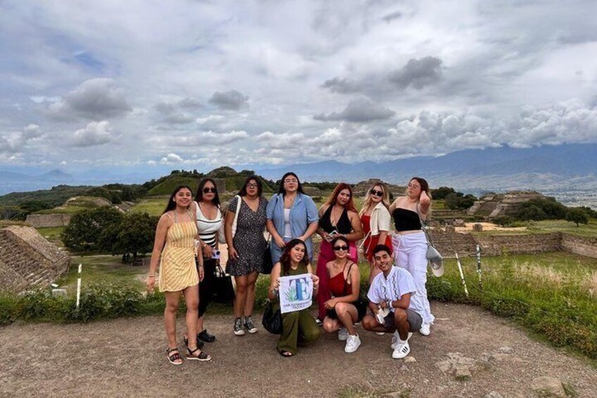 A group of people at an archaeological site with ancient ruins and a cloudy sky. 5