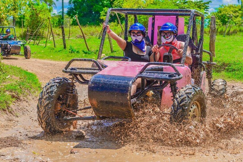 Un quad rouge avec deux personnes portant des casques et des bandanas, circulant sur un chemin boueux. 5