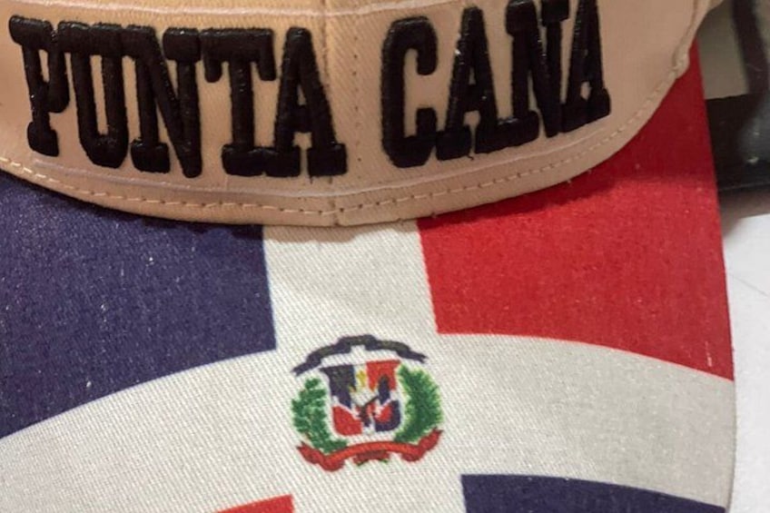 Une casquette de couleur fauve avec le mot « PONTA CANA » brodé en lettres noires. 2