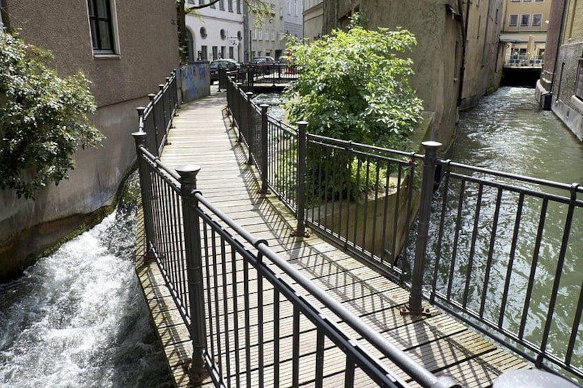 Un étroit canal, bordé d’une promenade en bois et muni d’une rambarde métallique. 2