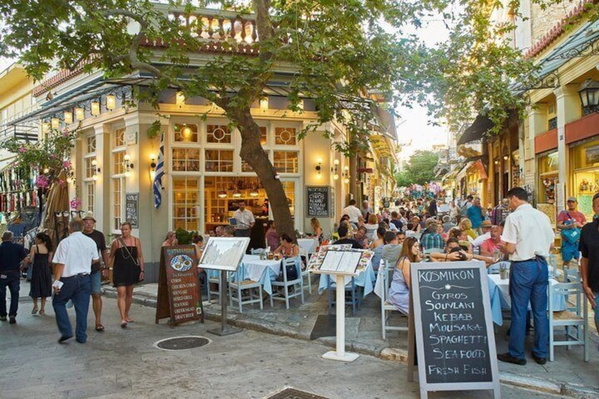 A bustling outdoor dining area with tables and chairs, surrounded by buildings with traditional architecture. 3