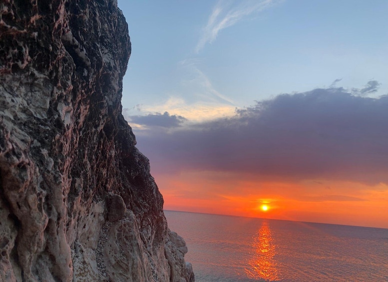 A rocky coastline at sunset with the sun reflecting on the water. 3