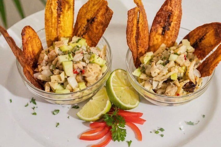 Two bowls of a salad with diced ingredients and grilled plantains, garnished with lime and parsley. 4