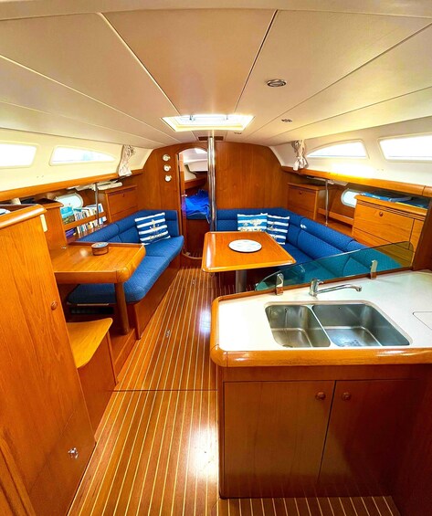 A compact galley with a sink, a small table, and blue upholstered seating. 2