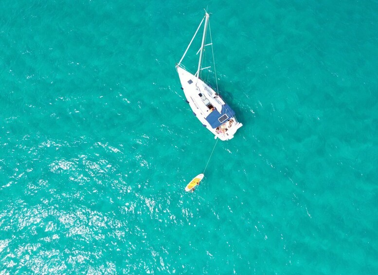 A sailboat anchored in turquoise waters. 3