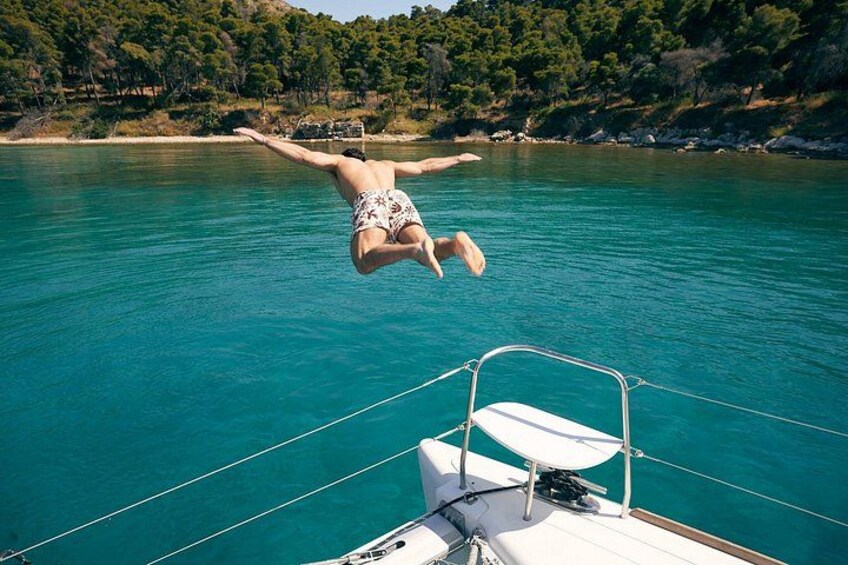 Une personne plongeant dans une eau turquoise depuis un bateau. 2