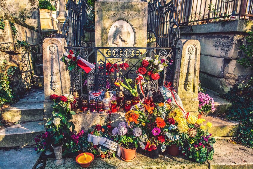 A cemetery with a gravestone, flowers, and memorial items. 2