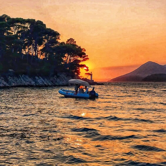 A sunset over a calm body of water with a boat and a distant mountain. 5