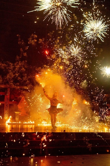 A person performing with fireworks in the background. 3