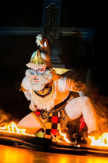 A performer in a white costume with a checkered pattern, flames, and a decorative background. 2