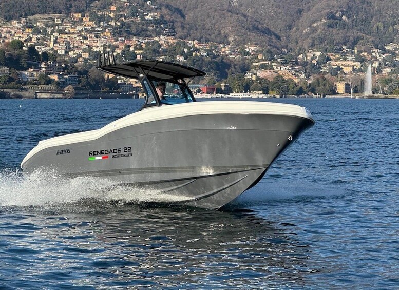 A speedboat named RENEGADE 22 on a lake with a town in the background. 1