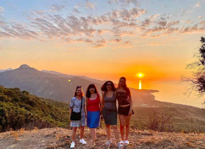 Four people standing on a hill with a sunset in the background. 3