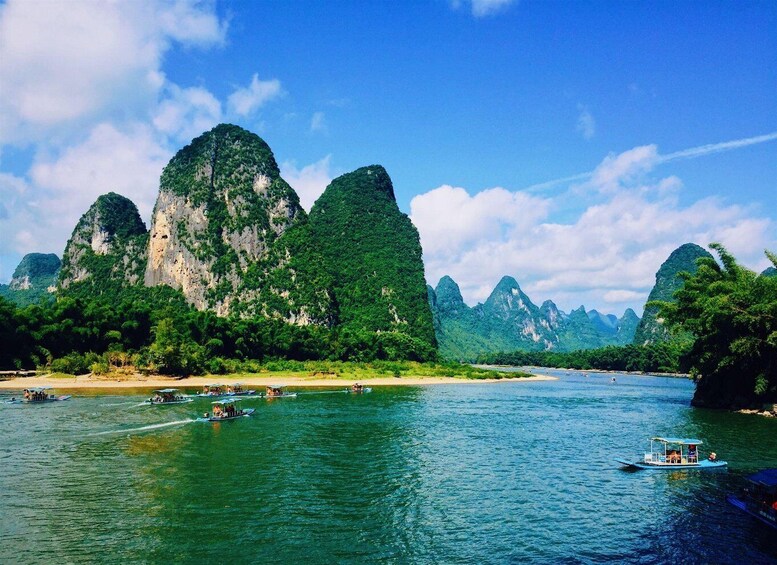 A river with boats, surrounded by lush green mountains. 5