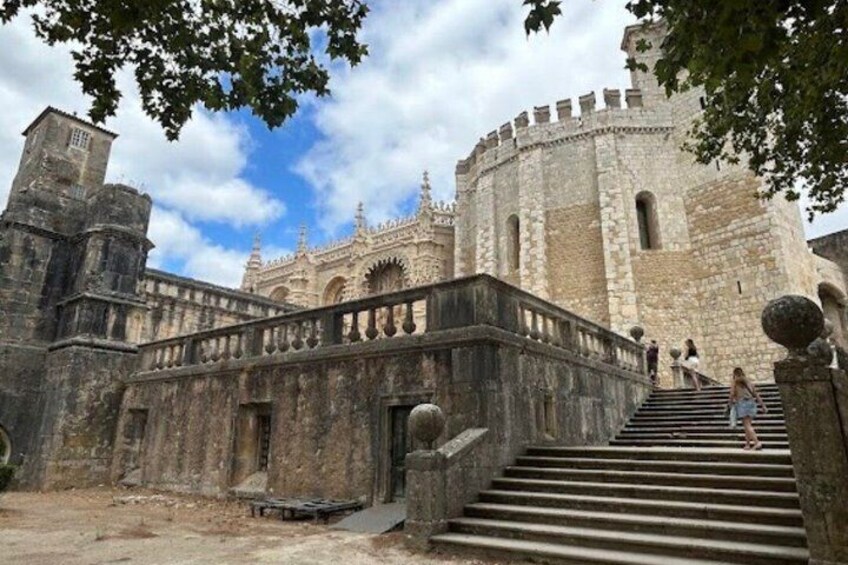 A historic stone building with a grand staircase leading to a balcony. 4