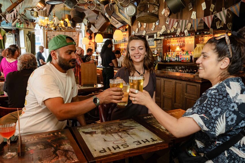 A bar with people toasting with beer glasses. 1