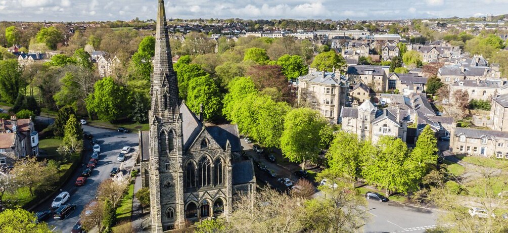 A church with a tall spire, surrounded by residential buildings and trees. 1