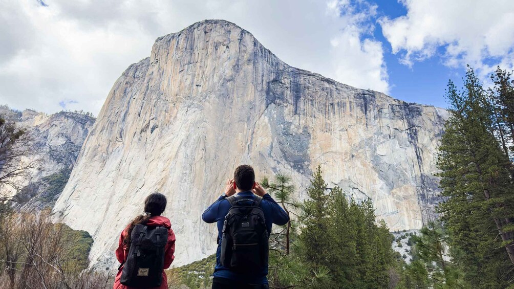 Two hikers looking at a large mountain. 1