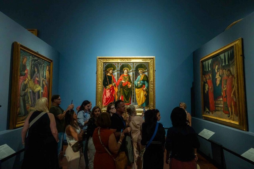 A group of people observing a painting in a museum. 4