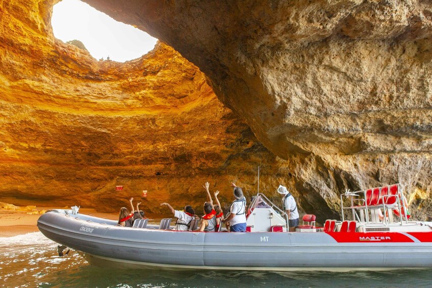 A boat with passengers enjoying a natural rock formation. 2