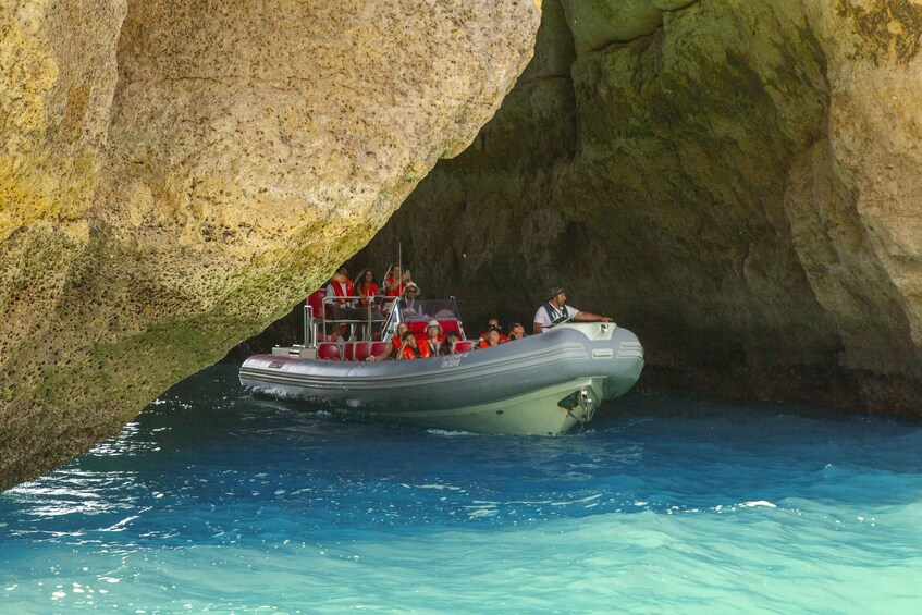 A boat with passengers navigating through a narrow waterway between large rock formations. 5