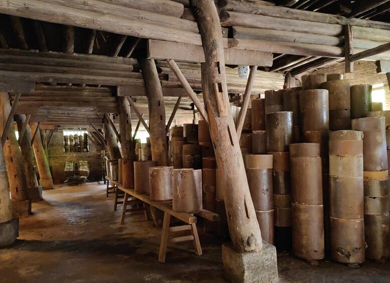 A wooden interior with large cylindrical objects stacked on shelves. 2