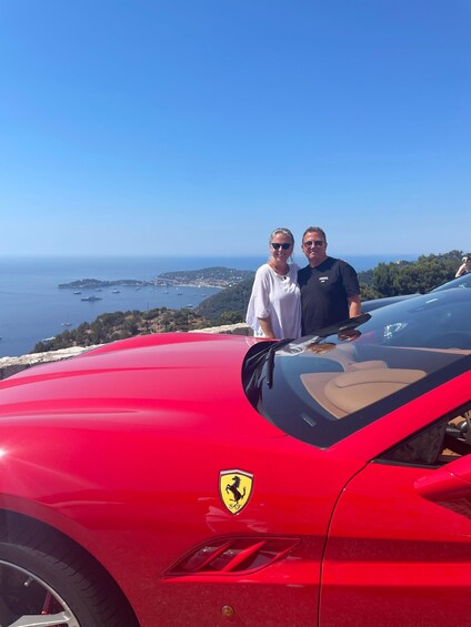 A red Ferrari parked on a coastal cliff overlooking the sea. 5
