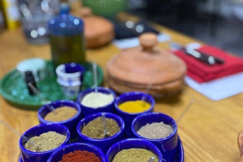 A table with various spices in blue containers. 1
