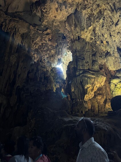A cave interior with stalactites and a light source at the top. 2
