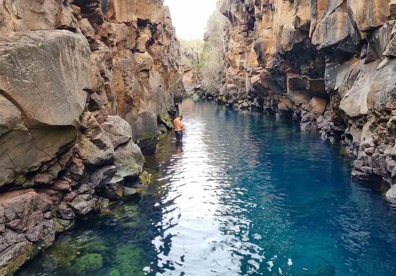 A canyon with clear blue water and rocky walls. 3