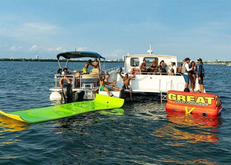 A group of people on a boat with a green and a red inflatable raft. 1