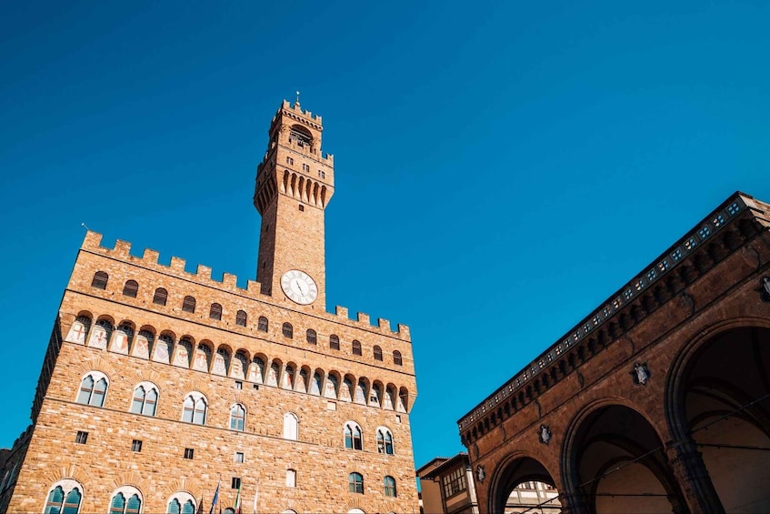 A historic building with a prominent clock tower and arched windows. 2