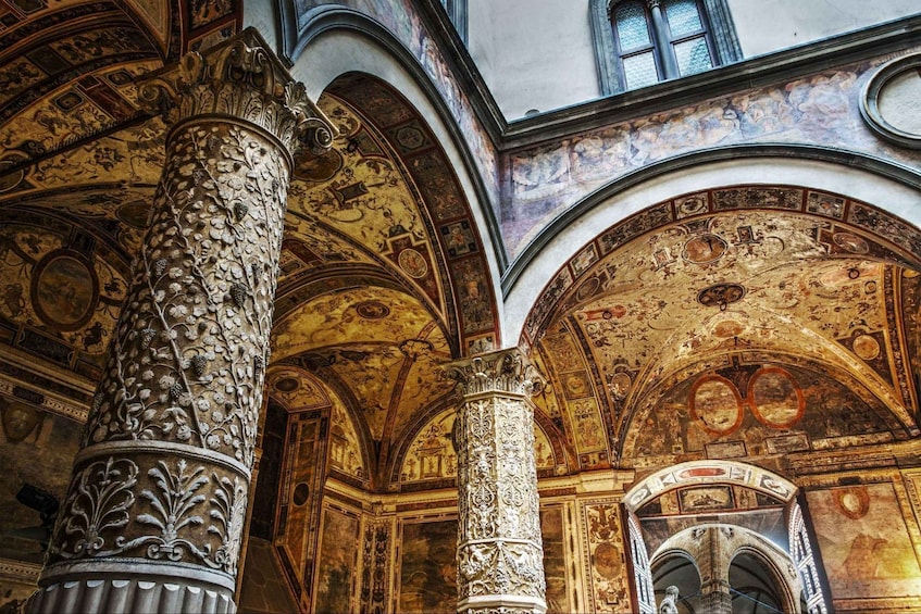Ornate columns and detailed frescoes in an interior space. 1