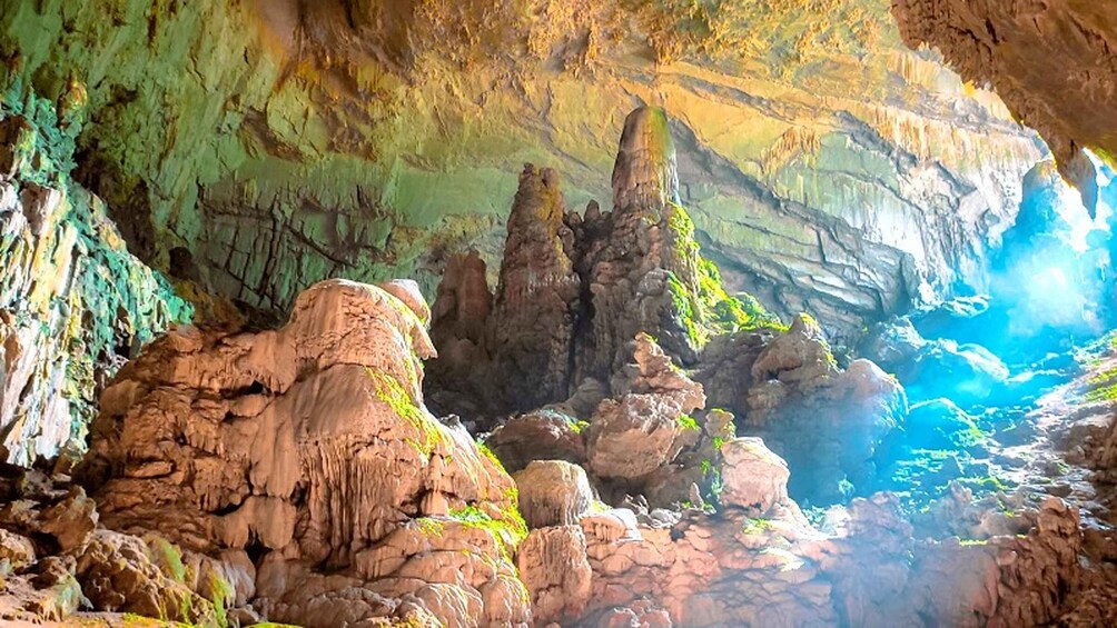A cave with stalactites and stalagmites, illuminated by natural light. 2