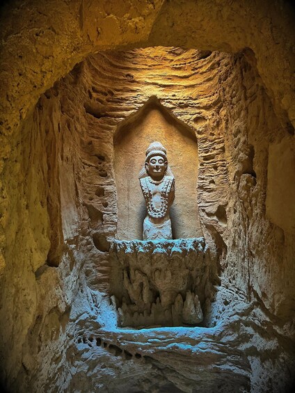 A carved Buddha statue in a cave. 4